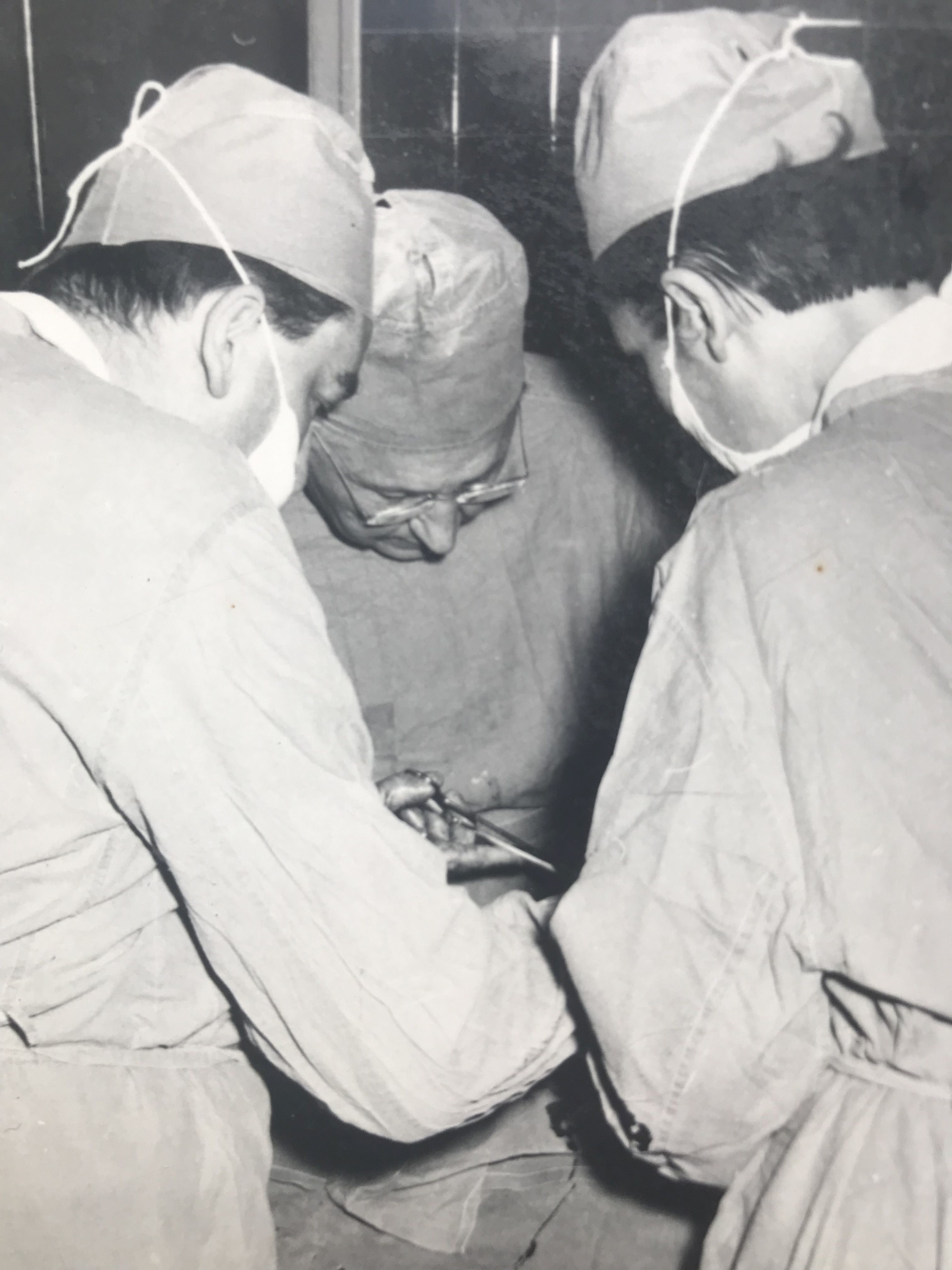 Czarno-biała fotografia przedstawia dw&oacute;ch operujących mężczyzn.